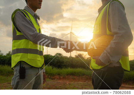 Teamwork of Asian windmill engineer group, worker working, shaking hands on site at wind turbines field or farm, renewable clean energy source. Eco technology for electric power. industry. People 78062088