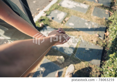 Young couple holding hands walking in pathway on sunny Young couple holding hands walking in pathway on sunny 78063259
