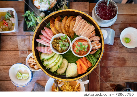 Set appetizer of Northern Thai Food with fried pork, sausage, vegetables and thai chili sauce dip on Khantoke or traditional container Set appetizer of Northern Thai Food with fried pork, sausage, vegetables and thai chili sauce dip on Khantoke or traditional container 78063790