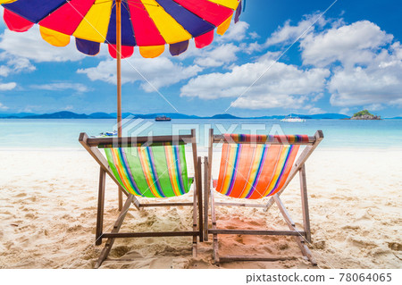 Two colorful beach chair with umbrella. 78064065