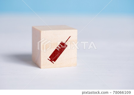 Red syringe sign on a wooden cube. 78066109