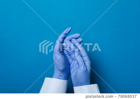 Doctor hands in medical gloves on blue background 78068037