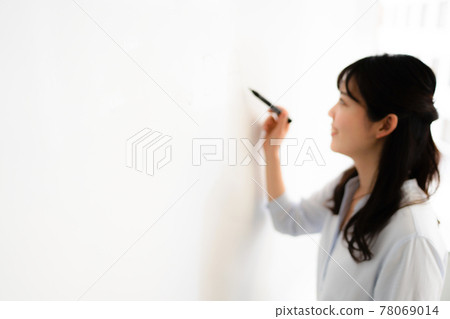 Woman writing letters on the whiteboard 78069014