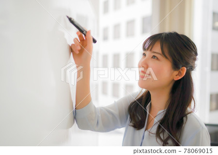 Woman writing letters on the whiteboard Woman writing letters on the whiteboard 78069015