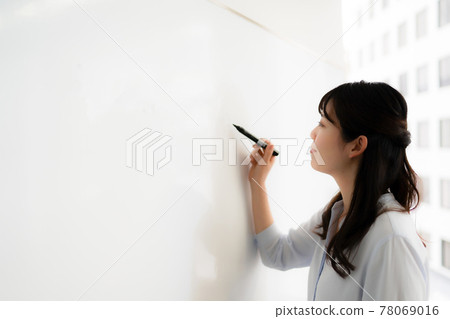 Woman writing letters on the whiteboard 78069016