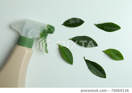 Blank detergent spray bottle and leaves on white background 78069136