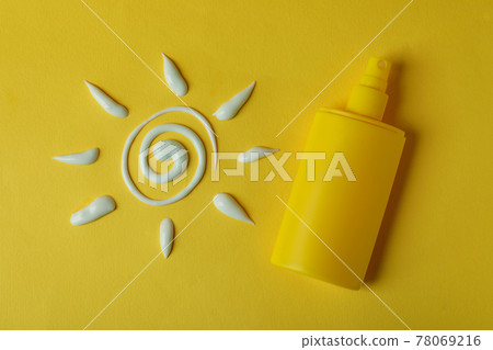 Sun made of sunscreen and bottle of cream on yellow background Sun made of sunscreen and bottle of cream on yellow background 78069216