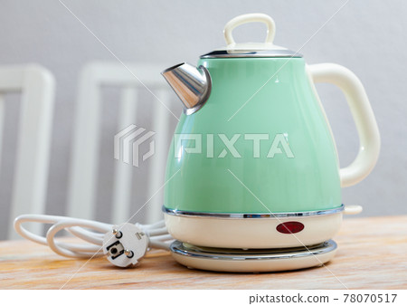 Turquoise electric tea kettle on wooden table Turquoise electric tea kettle on wooden table 78070517