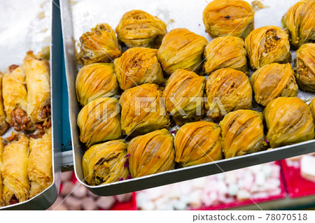 Sweet baklava with honey and nuts on showcase in Turkish confectionery Sweet baklava with honey and nuts on showcase in Turkish confectionery 78070518