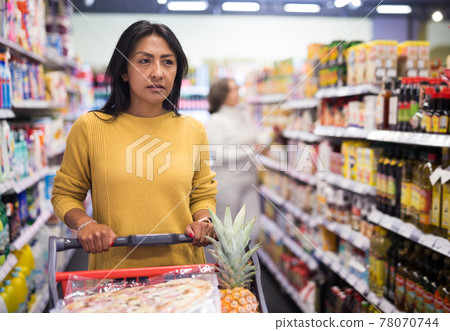 Latin american woman visiting supermarket food department for shopping Latin american woman visiting supermarket food department for shopping 78070744