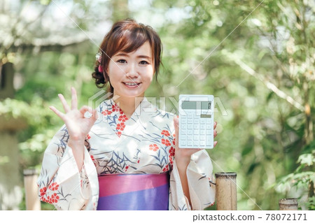 A woman in a yukata with a calculator A woman in a yukata with a calculator 78072171