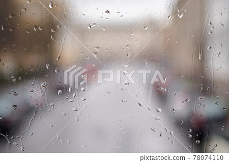 Raindrops on the glass. Blurred urban landscape through the window in the rain, rainy weather. 78074110