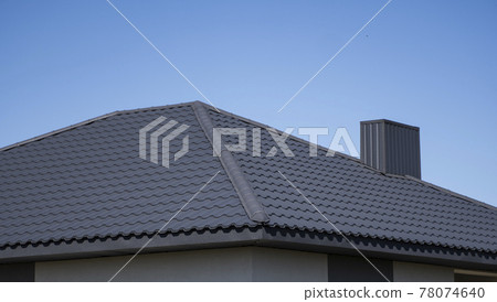 Brown corrugated metal profile roof installed on a modern house. The roof of corrugated sheet. Roofing of metal profile wavy shape. Modern roof made of metal. Metal roofing. 78074640