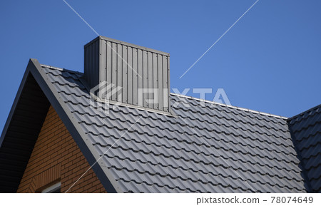 Grey corrugated metal profile roof installed on a modern house. The roof of corrugated sheet. Roofing of metal profile wavy shape. Modern roof made of metal. Metal roofing. Grey corrugated metal profile roof installed on a modern house. The roof of corrugated sheet. Roofing of metal profile wavy shape. Modern roof made of metal. Metal roofing. 78074649