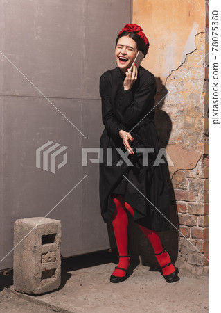 Young woman in the image of a famous artist, personality laughing isolated on vintage background. Retro style, comparison of eras concept. Young woman in the image of a famous artist, personality laughing isolated on vintage background. Retro style, comparison of eras concept. 78075380