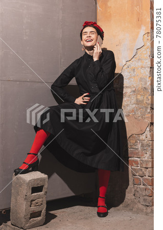 Young woman in the image of a famous artist, personality on vintage background. Retro style, comparison of eras concept. Young woman in the image of a famous artist, personality on vintage background. Retro style, comparison of eras concept. 78075381
