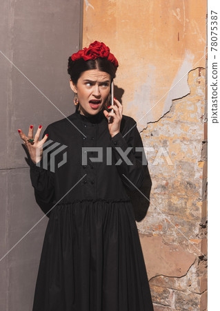 Portrait of young woman in the image of a famous artist, personality on vintage background. Retro style, comparison of eras concept. Portrait of young woman in the image of a famous artist, personality on vintage background. Retro style, comparison of eras concept. 78075387