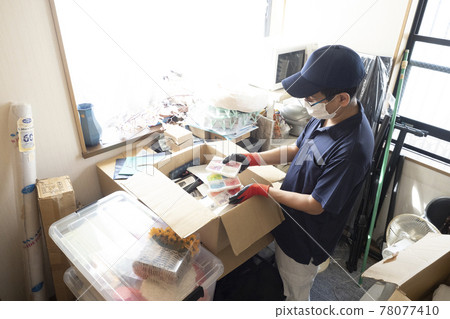 Male worker cleaning up a messy room 78077410