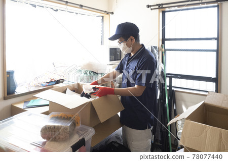 Male worker cleaning up a messy room Male worker cleaning up a messy room 78077440