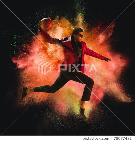 One young sportsman basketball player in explosion of colored neon powder isolated on dark background One young sportsman basketball player in explosion of colored neon powder isolated on dark background 78077481