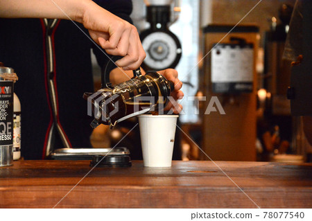 Coffee poured into a paper cup with a French press. 78077540