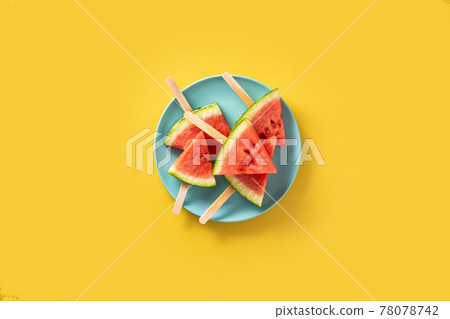Watermelon slices popsicles on blue plate Watermelon slices popsicles on blue plate 78078742