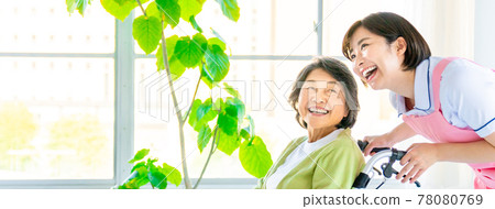 Nursing staff and senior women pushing a wheelchair 78080769