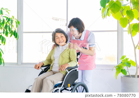 Senior woman in wheelchair and nursing staff Senior woman in wheelchair and nursing staff 78080770