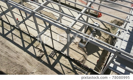 Reinforced Concrete Frame Of An Industrial Building. Camera Flight On A Construction Site. Beams With Steel Reinforcement. Dump Truck Unloads Sand in Construction. Aerial view. Unloading soil Reinforced Concrete Frame Of An Industrial Building. Camera Flight On A Construction Site. Beams With Steel Reinforcement. Dump Truck Unloads Sand in Construction. Aerial view. Unloading soil 78080995