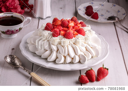 Red fruit pavlova with a cup of tea Red fruit pavlova with a cup of tea 78081988