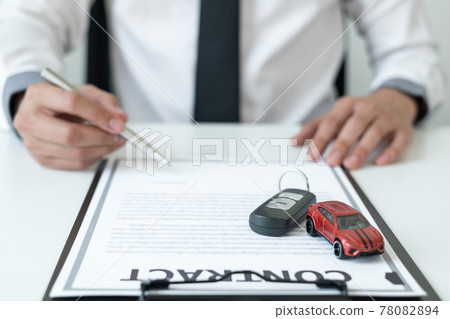 Car dealer businessman signing car insurance document or lease paper. Car loan and insurance concept 78082894