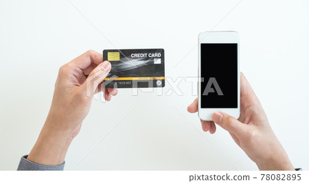 The businessman's hand is holding a credit card and using a smartphone for online shopping and internet payment in the office The businessman's hand is holding a credit card and using a smartphone for online shopping and internet payment in the office 78082895
