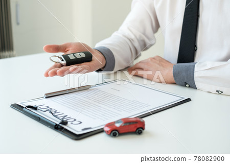 Car dealer businessman holding a car key. Car loan and insurance concept Car dealer businessman holding a car key. Car loan and insurance concept 78082900