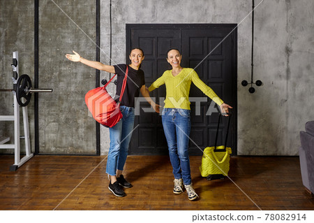 Arriving home after vacation, women are delighted to see their family. 78082914