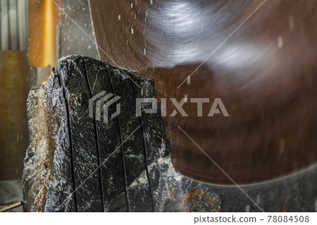 Large industrial cutting machine cuts gray granite stone into slabs Large industrial cutting machine cuts gray granite stone into slabs 78084508