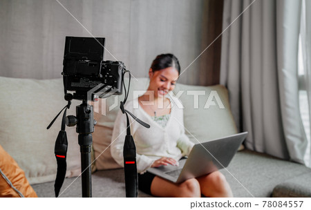 Asian blogger, podcaster or vlogger looking at camera and talking on video shooting with technology Asian blogger, podcaster or vlogger looking at camera and talking on video shooting with technology 78084557