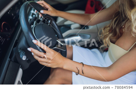 Close-up of a woman's hand on steering wheel in a modern car. Close-up of a woman's hand on steering wheel in a modern car. 78084594