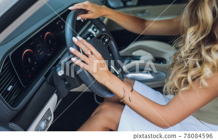 Close-up of a woman's hand on steering wheel in a modern car. 78084596