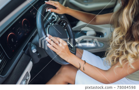 Close-up of a woman's hand on steering wheel in a modern car. 78084598
