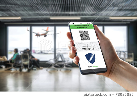 Traveler holds vaccine passport certificate to show COVID 19 vaccination status Traveler holds vaccine passport certificate to show COVID 19 vaccination status 78085885