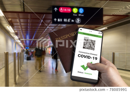 Traveler holds vaccine passport certificate to show COVID 19 vaccination status Traveler holds vaccine passport certificate to show COVID 19 vaccination status 78085991