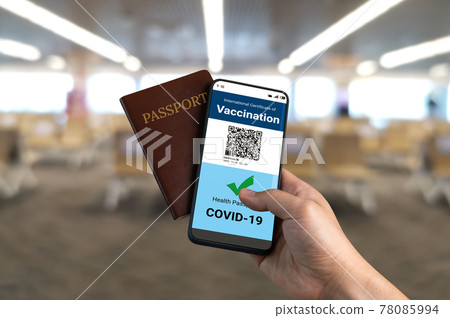 Traveler holds vaccine passport certificate to show COVID 19 vaccination status Traveler holds vaccine passport certificate to show COVID 19 vaccination status 78085994