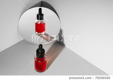 Creative photo with glass jar ofcosmetic oil and mirror Creative photo with glass jar ofcosmetic oil and mirror 78086080