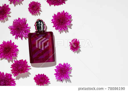 Bottle of fragrance surrounded by flower buds 78086190