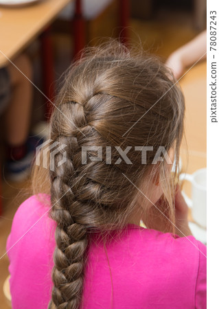 Close-up of a girl's hairstyle with a lush braid, view from the back 78087243