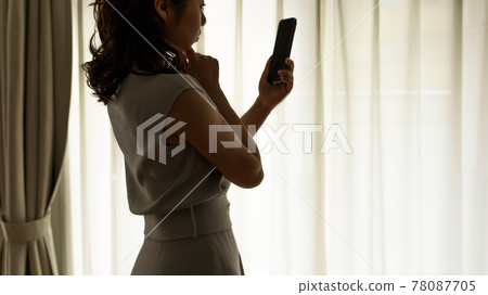 A woman who plays a smartphone 78087705