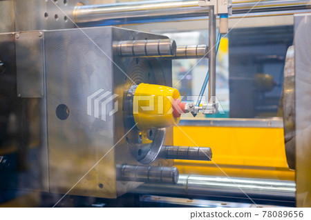 Injection molding machine during work: production of empty plastic cup: close up 78089656