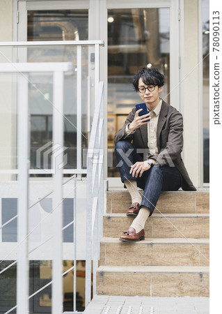 A young man looking at the screen of the smartphone A young man looking at the screen of the smartphone 78090113