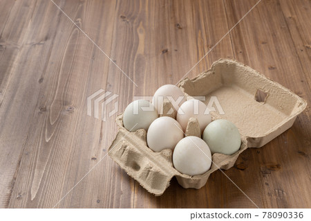 Picture of six egg in a paper box. The egg is white because they are duck egg not a chicken egg. They are organized in two rolls. The paper box is placed on the wooden table. Picture of six egg in a paper box. The egg is white because they are duck egg not a chicken egg. They are organized in two rolls. The paper box is placed on the wooden table. 78090336
