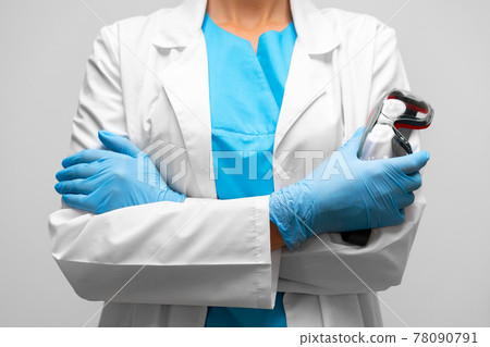 Unrecognizable woman doctor standing with crossed hands and holding protective glasses Unrecognizable woman doctor standing with crossed hands and holding protective glasses 78090791